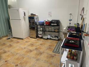 a kitchen with a refrigerator and a tiled floor at Shiyue Homestay in Zhuangwei