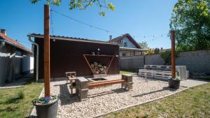 a backyard with a bench and a fire place at Kun Kuckó Vendégház in Kiskunmajsa
