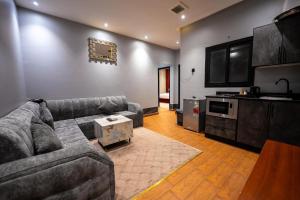 a living room with a couch and a kitchen at راحتي هنا للشقق المخدومة in Riyadh