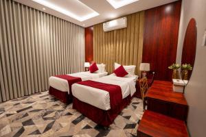 a hotel room with two beds with red pillows at راحتي هنا للشقق المخدومة in Riyadh