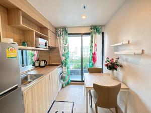 a small kitchen with a table and a refrigerator at Sanphawut IDEO CONDO in Bang Chak