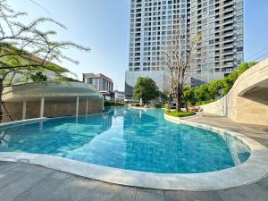 a large swimming pool in a city with tall buildings at Sanphawut IDEO CONDO in Bang Chak