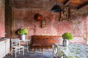 a patio with a wooden bench and a table and chairs at Agriturismo Le Spezie in Conegliano