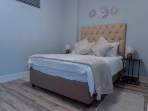 a bedroom with a large bed with white sheets and pillows at 77 ON Independence Avenue in Windhoek