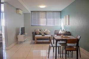 a living room with a table and a couch at 77 ON Independence Avenue in Windhoek +8 photos