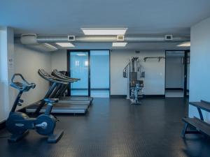 a gym with treadmills and ellipticals in a room at 77 ON Independence Avenue in Windhoek