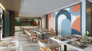 a restaurant with tables and chairs and a colorful wall at Swiss-Belexpress K Square Batam in Batam Center +19 photos
