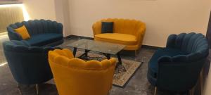 a waiting room with yellow and blue chairs and a table at Starry Hills Resort in Dwārīkhāl