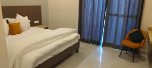 a bedroom with a bed with a blue curtain and a chair at Starry Hills Resort in Dwārīkhāl