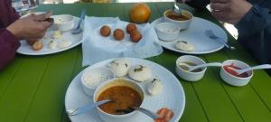 a table with plates of food on a green table at Starry Hills Resort in Dwārīkhāl