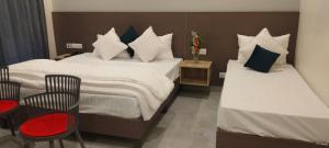 a hotel room with two beds and a table and chairs at Starry Hills Resort in Dwārīkhāl