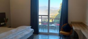 a room with a bed and a view of a balcony at Starry Hills Resort in Dwārīkhāl