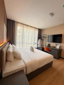 a hotel room with a large bed and a desk at I Fly Hotel BSI in Tawau