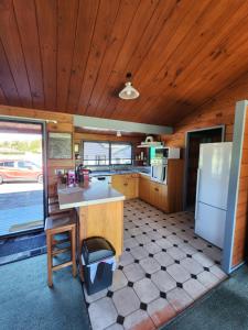 a kitchen with a refrigerator and a table in a room at Ruapehu Farm Chalet in Ohakune