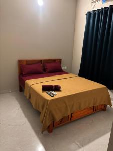 a bedroom with a bed with two remote controls on it at Md Couple Stay in Covelong