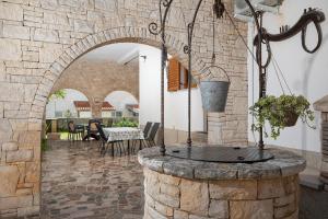 an outdoor patio with a stone wall and a stone fountain at Apartments Dadic with parking & playground in Medulin