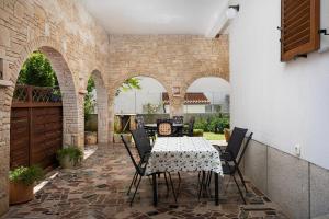 a patio with a table and chairs on a brick wall at Apartments Dadic with parking & playground in Medulin