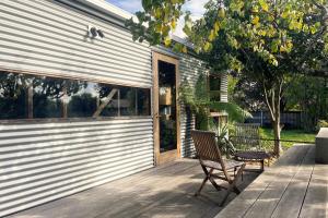 a wooden chair sitting on a deck next to a building at Suite Shed, Unique accessible private guest suite in Launceston in Launceston
