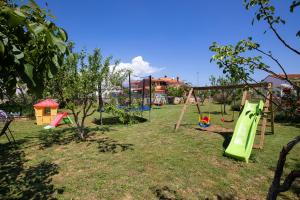 a park with a playground with swings at Apartments Dadic with parking & playground in Medulin