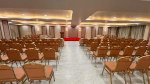 a large room with rows of chairs and a podium at Hotel Green Woodd in Anand