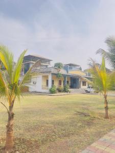 a house with two palm trees in front of it at New Central villa in Bapsai