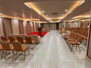 a room with rows of chairs and a podium at Hotel Green Woodd in Anand +18 photos