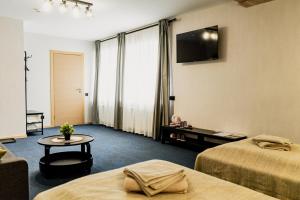 a hotel room with two beds and a tv at Naktsmītne - Fišers in Viesīte