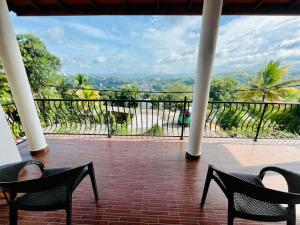 a balcony with chairs and a view of the mountains at Villa Avora Ridge in Kandy