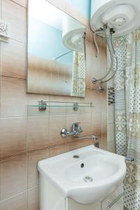 a bathroom with a white sink and a mirror at Apartments Diana in Luka +77 photos