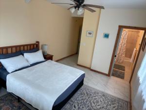 a bedroom with a bed and a ceiling fan at Silver Dollar Tree in Kealakekua