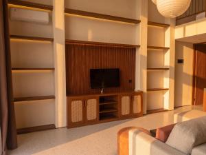 a living room with a tv and a couch at Frontera Nyanyi in Tabanan