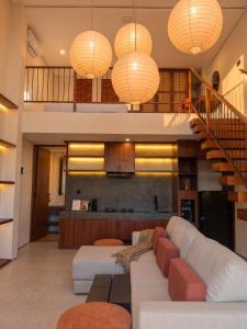 a living room with a couch and a staircase at Frontera Nyanyi in Tabanan