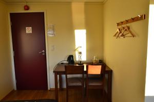 a room with a desk and a table and a door at VIKEDAL VERTSHUS hotel in Vikedal