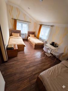 a room with two beds and a table and a desk at Dilijan Rest - Comfortable rooms & Pool in Dilijan +74 photos