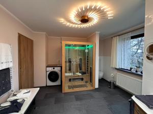 a bathroom with a shower and a washer at Ferienwohnung Zum Gartenparadies in Oppach