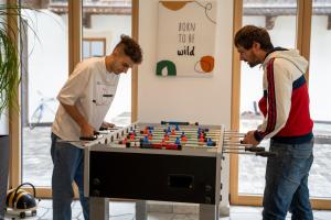 two men standing next to a table with a chessboard at Preindlerhof Farmloft in Valle Di Casies