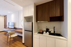 a kitchen with white cabinets and a white refrigerator at Osea Hotel in Sihanoukville