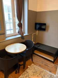 a small room with a table and a desk and a bed at Gengoult 1 in Toul