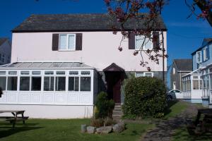 ein weißes Haus mit einem Wintergarten an der Seite in der Unterkunft Ivy Tower Cottages in Saint Florence