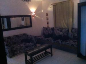 a living room with couches and a table and a mirror at Sky Roof Suite in Marsa Alam City