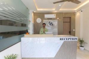 a man standing behind a reception counter in an office at Hotel Ganga Stone in Rāiwāla