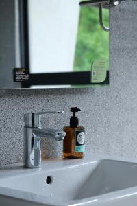 a bathroom sink with a bottle of soap on it at Tao Ye BnB in Miaoli