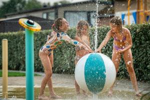three children playing in a water park at Siblu Duinzicht in Koudekerke