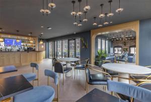 a restaurant with tables and chairs and a bar at The Hotel Monroe, Tapestry Collection By Hilton in Monroe