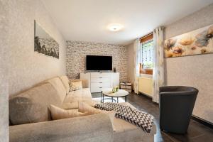 a living room with a couch and a tv at Ferienhaus Mayer in Idar-Oberstein