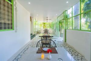 a room with two tables and chairs and windows at Virasat-1969 in Udaipur
