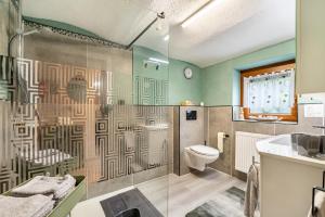 a bathroom with a shower with a toilet and a sink at Ferienhaus Mayer in Idar-Oberstein +25 photos