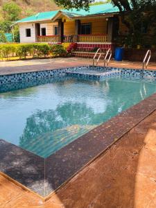 a swimming pool in front of a house at Royal Nest Villa in Mahabaleshwar
