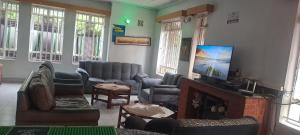 a living room with couches chairs and a fireplace at Tommy's Lounge Apartments in Nairobi