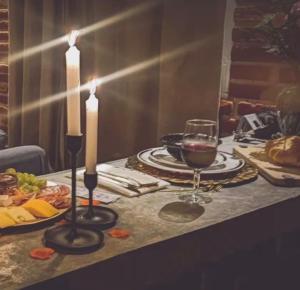 ein Tisch mit zwei Kerzen und einem Glas Wein in der Unterkunft Chalet MQSTO in La Cañada